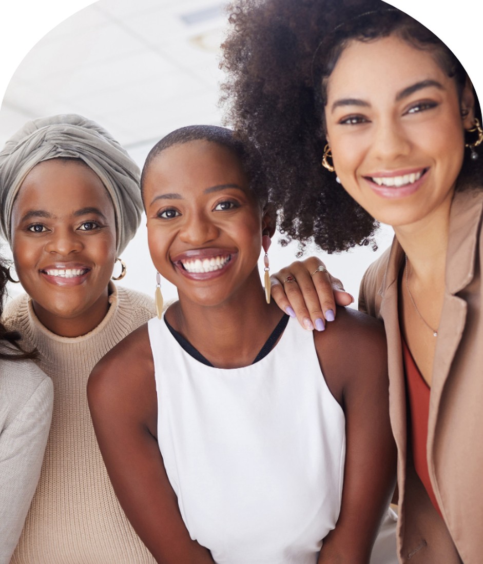 Three women smiling together in a supportive community
